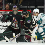 San Jose Sharks right wing Kevin Labanc (62) scores a goal getting the puck past Arizona Coyotes goaltender Karel Vejmelka, left, and Coyotes defenseman J.J. Moser (90) during the first period of an NHL hockey game in Tempe, Ariz., Tuesday, Jan. 10, 2023. (AP Photo/Ross D. Franklin)