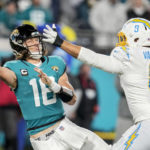 
              Jacksonville Jaguars quarterback Trevor Lawrence (16) tries to throw a pass under pressure by Los Angeles Chargers linebacker Kyle Van Noy (8) during the second half of an NFL wild-card football game, Saturday, Jan. 14, 2023, in Jacksonville, Fla. (AP Photo/John Raoux)
            
