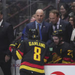 
              Vancouver Canucks coach Rick Tocchet, back center, talks to Conor Garland (8) as defensive development coach Sergei Gonchar, right, listens while assistant coach Adam Foote, left, stands behind the bench during the first period of the team's NHL hockey game against the Chicago Blackhawks on Tuesday, Jan. 24, 2023, in Vancouver, British Columbia. (Darryl Dyck/The Canadian Press via AP)
            