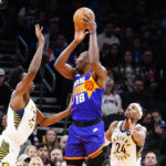 Phoenix Suns' Bismack Biyombo (18) shoots between Indiana Pacers' Jalen Smith, left, and Buddy Field, right, during the first half of an NBA basketball game in Phoenix, Saturday, Jan. 21, 2023. (AP Photo/Darryl Webb)