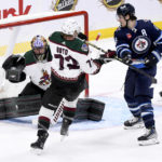 
              Arizona Coyotes goaltender Karel Vejmelka, left, makes a save against a Winnipeg Jets shot as Coyotes center Travis Boyd (72) and Jets center Mark Scheifele (55) battle in front of the net during first-period NHL hockey game action in Winnipeg, Manitoba, Sunday, Jan. 15, 2023. (Fred Greenslade/The Canadian Press via AP)
            