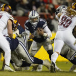 Dallas Cowboys quarterback Dak Prescott (4) looking for an opening against the Washington Commanders during the second half an NFL football game, Sunday, Jan. 8, 2023, in Landover, Md. (AP Photo/Patrick Semansky)