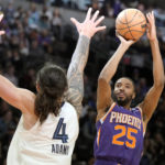 Phoenix Suns forward Mikal Bridges, right, shoots over Memphis Grizzlies center Steven Adams (4) during the second half of an NBA basketball game, Sunday, Jan. 22, 2023, in Phoenix. (AP Photo/Rick Scuteri)