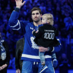 
              Toronto Maple Leafs center John Tavares holds his child during a pregame ceremony for reaching 1,000 career games, before an NHL hockey game against the Washington Capitals in Toronto on Sunday, Jan. 29, 2023. (Cole Burston/The Canadian Press via AP)
            