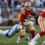 San Francisco 49ers quarterback Brock Purdy (13) is sacked by Dallas Cowboys defensive end DeMarcus Lawrence, bottom, during the first half of an NFL divisional round playoff football game in Santa Clara, Calif., Sunday, Jan. 22, 2023. (AP Photo/Josie Lepe)