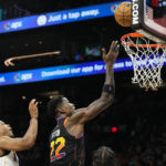 Phoenix Suns center Deandre Ayton (22) releases a shot after getting past Miami Heat guard Kyle Lowry, left, during the second half of an NBA basketball game in Phoenix, Friday, Jan. 6, 2023. The Heat won 104-96. (AP Photo/Ross D. Franklin)