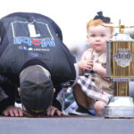 
              FILE - Piper Harvick looks on as her father Kevin Harvick kisses the yard of bricks on the finish line after winning the NASCAR Brickyard 400 auto race at Indianapolis Motor Speedway, Sunday, Sept. 8, 2019, in Indianapolis. Kevin Harvick said Thursday, Jan. 12, 2023, he will retire from NASCAR competition at the end of the 2023 season. (AP Photo/AJ Mast, File)
            