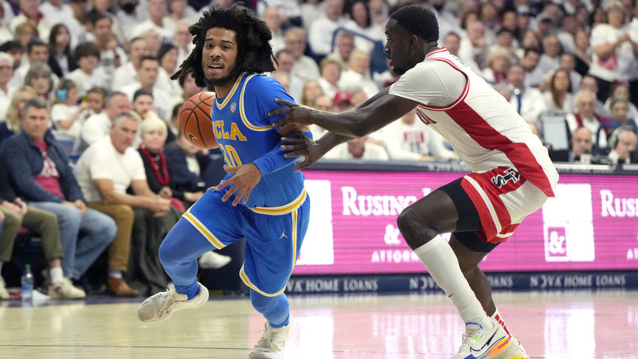 UCLA guard Tyger Campbell (10) drives past Arizona guard Courtney Ramey during the first half of an...