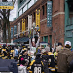 Vendor Patricia Almquist sells programs and souvenirs prior to the NHL Winter Classic hockey game between the Pittsburgh Penguins and Boston Bruins at Fenway Park, Monday, Jan. 2, 2023, in Boston. (AP Photo/Charles Krupa)