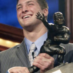 
              FILE - Florida quarterback Tim Tebow holds up the Heisman Trophy after winning the award Saturday, Dec. 8, 2007 in New York. Tebow was elected to the College Football Hall of Fame, Monday, Jan. 9, 2023. (AP Photo/Kelly Kline, Pool, File)
            