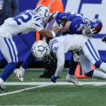 New York Giants' Daniel Bellinger (82) is tackled by Indianapolis Colts' Stephon Gilmore (5) and Julian Blackmon (32) during the first half of an NFL football game, Sunday, Jan. 1, 2023, in East Rutherford, N.J. (AP Photo/Bryan Woolston)