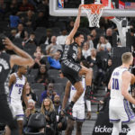 
              San Antonio Spurs' Tre Jones, center, dunks during the first half of an NBA basketball game against the Sacramento Kings, Sunday, Jan. 15, 2023, in San Antonio. (AP Photo/Darren Abate)
            