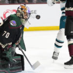 Arizona Coyotes goaltender Karel Vejmelka takes a shot off his facemask during the second period of an NHL hockey game against the San Jose Sharks in Tempe, Ariz., Tuesday, Jan. 10, 2023. (AP Photo/Ross D. Franklin)