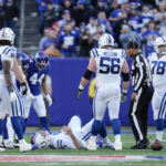 Players gather around Indianapolis Colts quarterback Nick Foles after he was injured during the first half of an NFL football game against the New York Giants, Sunday, Jan. 1, 2023, in East Rutherford, N.J. (AP Photo/Bryan Woolston)