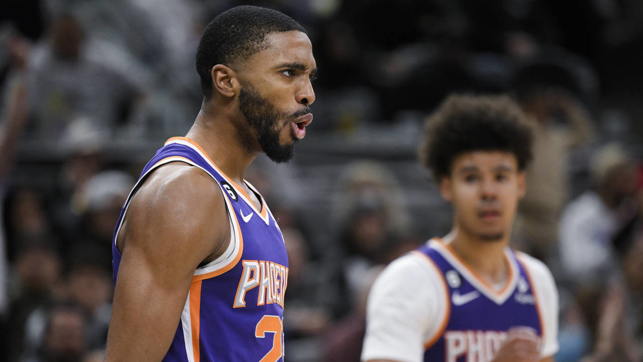 Phoenix Suns' Mikal Bridges, left, celebrates after a basket during the second half of an NBA baske...