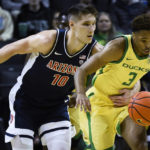 Arizona forward Azuolas Tubelis (10) reaches around to try to steal the ball from Oregon guard Keeshawn Barthelemy (3) during the first half of an NCAA college basketball game Saturday, Jan. 14, 2023, in Eugene, Ore. (AP Photo/Andy Nelson)