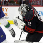 Carolina Hurricanes goaltender Pyotr Kochetkov (52) catches a shot by the Vancouver Canucks during the first period of an NHL hockey game in Raleigh, N.C., Sunday, Jan. 15, 2023. (AP Photo/Karl B DeBlaker)