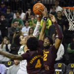 Arizona State guard Desmond Cambridge Jr. (4) blocks the shot of Oregon guard Will Richardson, left, as Arizona State forward Warren Washington, right, also defends on the play during the first half of an NCAA college basketball game Thursday, Jan. 12, 2023, in Eugene, Ore. (AP Photo/Andy Nelson)