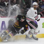 Vancouver Canucks' Sheldon Dries, left, and Chicago Blackhawks' Seth Jones collide during the third period of an NHL hockey game Tuesday, Jan. 24, 2023, in Vancouver, British Columbia. (Darryl Dyck/The Canadian Press via AP)