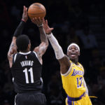 Brooklyn Nets guard Kyrie Irving (11) looks to shoot over Los Angeles Lakers guard Dennis Schroder (17) during the second half of an NBA basketball game Monday, Jan. 30, 2023, in New York. (AP Photo/Corey Sipkin)