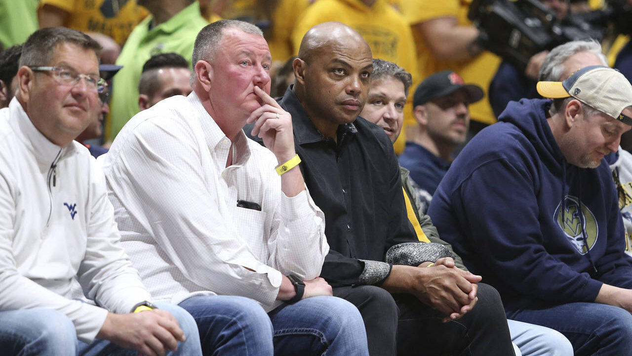 Former NBA player Charles Barkley, center, watches West Virginia and Auburn from the sideline durin...