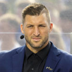 
              FILE - SEC Nation host Tim Tebow listens to his co-hosts during the SEC Nation broadcast in Lexington, Ky., Saturday, Oct. 9, 2021. Tebow, who won the Heisman in 2007, was elected to the College Football Hall of Fame, Monday, Jan. 9, 2023. (AP Photo/Michael Clubb, File)
            