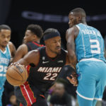 
              Miami Heat forward Jimmy Butler (22) drives into Charlotte Hornets guard Terry Rozier (3) during the first half of an NBA basketball game in Charlotte, N.C., Sunday, Jan. 29, 2023. (AP Photo/Nell Redmond)
            