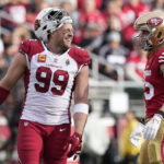 Arizona Cardinals defensive end J.J. Watt (99) smiles while talking with San Francisco 49ers tight end George Kittle during the first half of an NFL football game in Santa Clara, Calif., Sunday, Jan. 8, 2023. (AP Photo/Godofredo A. Vásquez)