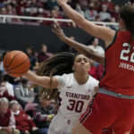 Stanford guard Haley Jones (30) passes the ball while defended by Utah forwards Jenna Johnson (22) and Dasia Young during the first half of an NCAA college basketball game in Stanford, Calif., Friday, Jan. 20, 2023. (AP Photo/Godofredo A. Vásquez)