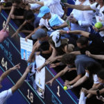 
              Stefanos Tsitsipas of Greece signs autographs after defeating Karen Khachanov of Russia in their semifinal at the Australian Open tennis championship in Melbourne, Australia, Friday, Jan. 27, 2023. (AP Photo/Ng Han Guan)
            