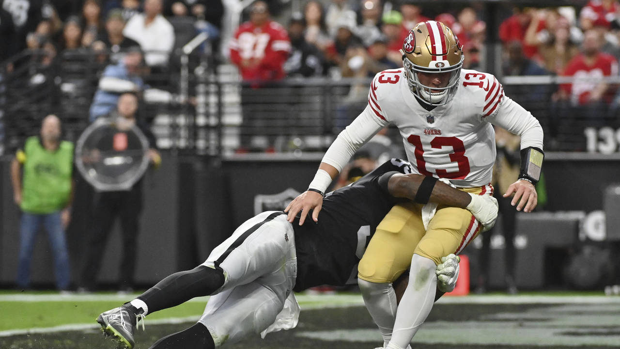 San Francisco 49ers quarterback Brock Purdy (13) is tackled by Las Vegas Raiders defensive end Isaa...