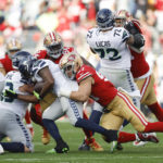 San Francisco 49ers defensive end Nick Bosa, right, tackles Seattle Seahawks running back DeeJay Dallas during the first half of an NFL wild card playoff football game in Santa Clara, Calif., Saturday, Jan. 14, 2023. (AP Photo/Jed Jacobsohn)