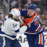 Tampa Bay Lightning left wing Pat Maroon (14) and Edmonton Oilers' Klim Kostin (21) fight during the second period of an NHL hockey game Thursday, Jan. 19, 2023, in Edmonton, Alberta. (Jason Franson/The Canadian Press via AP)
