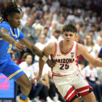 Arizona guard Kerr Kriisa (25) drives on UCLA guard Dylan Andrews during the second half of an NCAA college basketball game, Saturday, Jan. 21, 2023, in Tucson, Ariz. Arizona won 58-52. (AP Photo/Rick Scuteri)