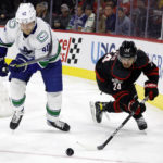 Carolina Hurricanes' Seth Jarvis (24) moves the puck around Vancouver Canucks' Elias Pettersson (40) during the second period of an NHL hockey game in Raleigh, N.C., Sunday, Jan. 15, 2023. (AP Photo/Karl B DeBlaker)