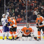 Toronto Maple Leafs' John Tavares, left, celebrates a goal scored by teammate Conor Timmins past Philadelphia Flyers goaltender Carter Hart, second from right, during the second period of an NHL hockey game, Sunday, Jan. 8, 2023, in Philadelphia. (AP Photo/Derik Hamilton)