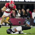 Georgia tight end Brock Bowers (19) leaps over TCU safety Millard Bradford (28) during the second half of the national championship NCAA College Football Playoff game, Monday, Jan. 9, 2023, in Inglewood, Calif. (AP Photo/Ashley Landis)