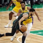 Boston Celtics' Jayson Tatum, front, drives past Los Angeles Lakers' Troy Brown Jr. during the first half of an NBA basketball game, Saturday, Jan. 28, 2023, in Boston. (AP Photo/Michael Dwyer)