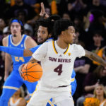 Arizona State's Desmond Cambridge Jr. (4) turns around on UCLA's Tyger Campbell (10) during the first half of an NCAA college basketball game, Thursday, Jan. 19, 2023, in Tempe, Ariz. (AP Photo/Darryl Webb)