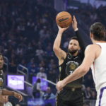Golden State Warriors guard Stephen Curry, middle, shoots a 3-point basket against the Phoenix Suns during the first half of an NBA basketball game in San Francisco, Tuesday, Jan. 10, 2023. (AP Photo/Godofredo A. Vásquez)