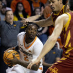 Iowa State's Caleb Grill (2) and Robert Jones (12) guard Oklahoma State's Chris Harris Jr. (2) during the first half of the NCAA college basketball game in Stillwater, Okla., Saturday, Jan. 21, 2023. (AP Photo/Mitch Alcala)