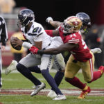 Seattle Seahawks quarterback Geno Smith (7) is pressured by San Francisco 49ers defensive end Charles Omenihu (94) during the second half of an NFL wild card playoff football game in Santa Clara, Calif., Saturday, Jan. 14, 2023. (AP Photo/Godofredo A. Vásquez)