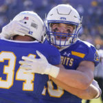 
              CORRECTS TO NORTH DAKOTA STATE NOT NORTH DAKOTA - South Dakota State fullback Michael Morgan (34) is hugged by teammate Jaxon Janke (10) after scoring a touchdown during the first half of the FCS Championship NCAA college football game against North Dakota State, Sunday, Jan. 8, 2023, in Frisco, Texas. (AP Photo/LM Otero)
            