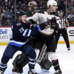 Arizona Coyotes defenceman Jakob Chychrun (6) defends Winnipeg Jets center Karson Kuhlman (20) in front of Coyotes goaltender Karel Vejmelka (70) during the second period of an NHL hockey game in Winnipeg, Manitoba, on Sunday, Jan. 15, 2023. (Fred Greenslade/The Canadian Press via AP)