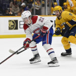 Montreal Canadiens right wing Cole Caufield (22) moves the puck ahead of Nashville Predators left wing Filip Forsberg (9) during the first period of an NHL hockey game Tuesday, Jan. 3, 2023, in Nashville, Tenn. (AP Photo/Mark Zaleski)