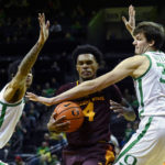 Oregon centers Kel'el Ware, left, and Nate Bittle (32) defend against Arizona State guard Desmond Cambridge Jr. (4) who drives the lane during the second half of an NCAA college basketball game Thursday, Jan. 12, 2023, in Eugene, Ore. (AP Photo/Andy Nelson)