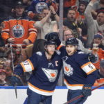 Edmonton Oilers' Connor McDavid (97) and Cody Ceci (5) celebrate a goal against the Chicago Blackhawks during the second period of an NHL hockey game Saturday, Jan. 28, 2023, in Edmonton, Alberta. (Jason Franson/The Canadian Press via AP)