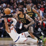 Toronto Raptors guard Gary Trent Jr. (33) and New York Knicks guard Jalen Brunson (11) try to get possession of the ball during the first half of an NBA basketball game Friday, Jan. 6, 2023, in Toronto. (Cole Burston/The Canadian Press via AP)