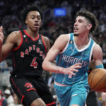 
              Charlotte Hornets guard LaMelo Ball is defended by Toronto Raptors forward Scottie Barnes (4) during the second half of an NBA basketball game Thursday, Jan. 12, 2023, in Toronto. (Frank Gunn/The Canadian Press via AP)
            
