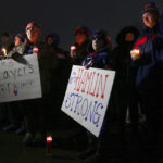 FILE - Joey Wetzler, left and Johnny Wetzler, right, hold sings of support during a candlelight vigil for Buffalo Bills safety Damar Hamlin on Tuesday, Jan. 3, 2023, in Orchard Park, N.Y. The Buffalo Bills have been a reliable bright spot for a city that has been shaken by a racist mass shooting and back-to-back snowstorms in recent months. So when Bills safety Damar Hamlin was critically hurt in a game Monday, the city quickly looked for ways to support the team. (AP Photo/Joshua Bessex, File)